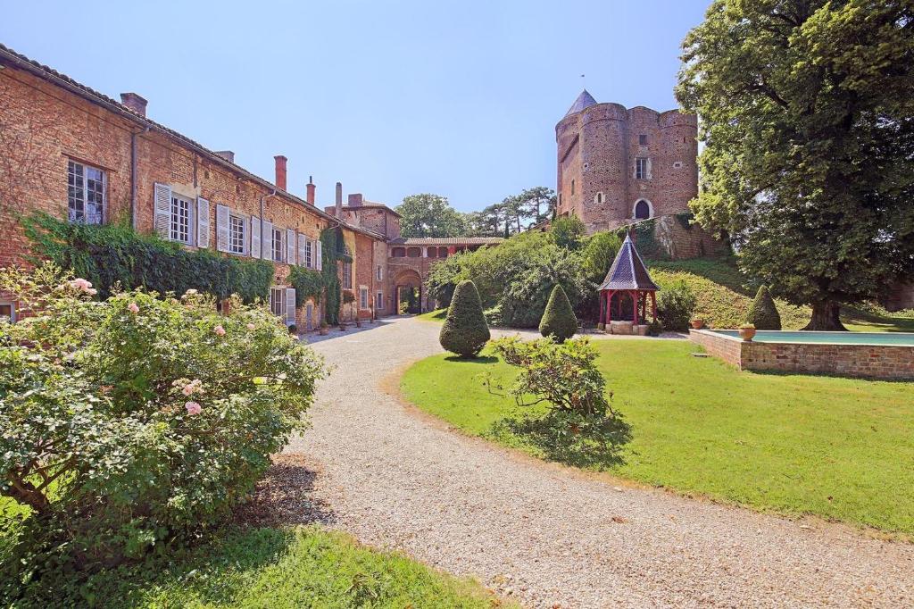 un chemin menant à un château avec un bâtiment dans l'établissement Château du Montellier, à Le Montellier