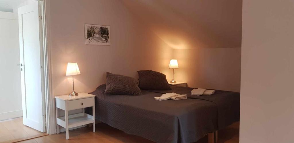 una camera da letto con un letto con due lampade sopra di Gula huset a Göteborg