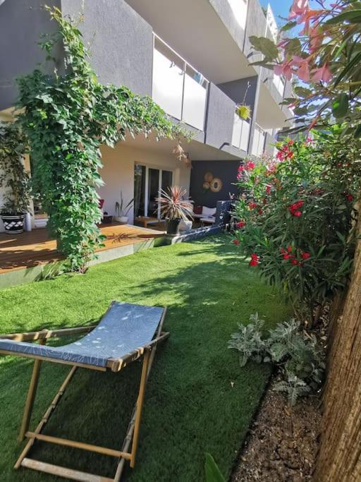 une maison avec une pelouse et une chaise dans la cour dans l'établissement Appartement moderne 6 personnes terrasse et jardin, à Castelnau-le-Lez