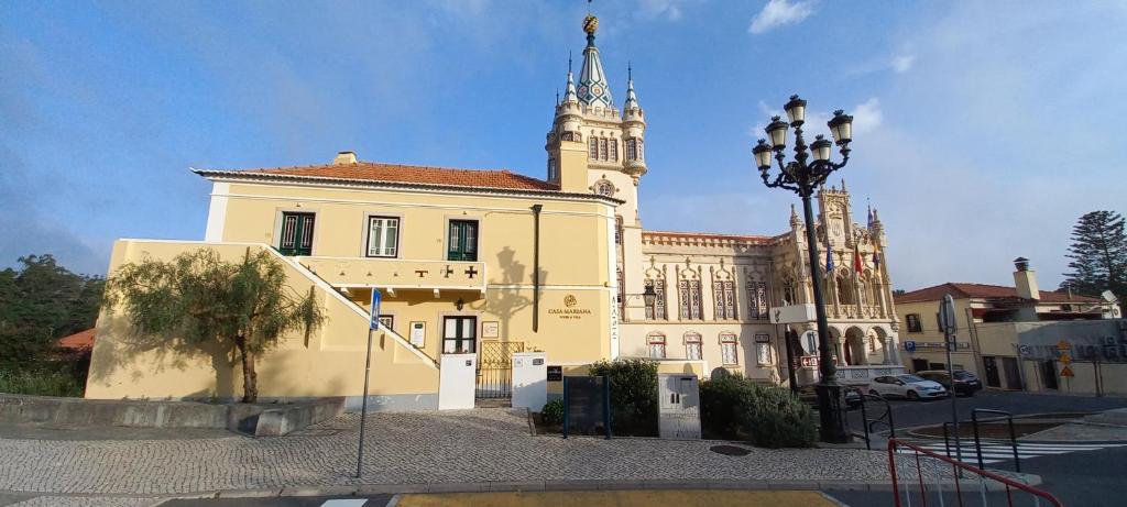 辛特拉的住宿－CASA MARIANA 1 - Viver a Vila，一座黄色的大建筑,设有钟楼