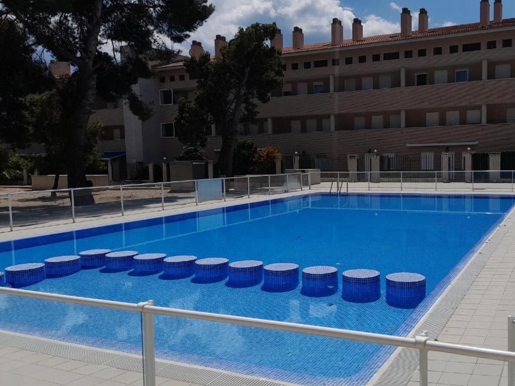 une grande piscine bleue avec un bâtiment en arrière-plan dans l'établissement UMA luna al sol Benicarlo-Peñiscola, à Benicarló