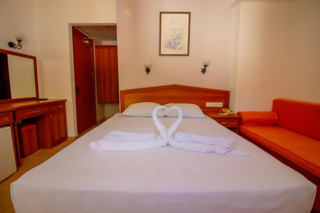 a bedroom with a bed with two white towels at Celeste Hotel in Fethiye