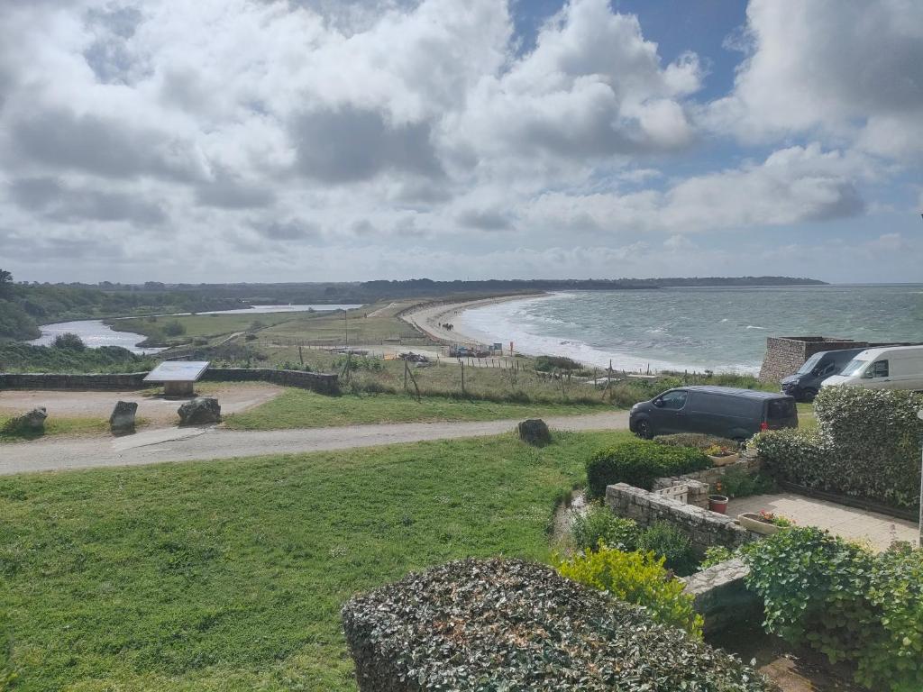 une vue d'une plage avec une voiture garée sur une route dans l'établissement Ref 031 T3 mezzanine vue mer à louer pour 4-6 personnes, à Arzon