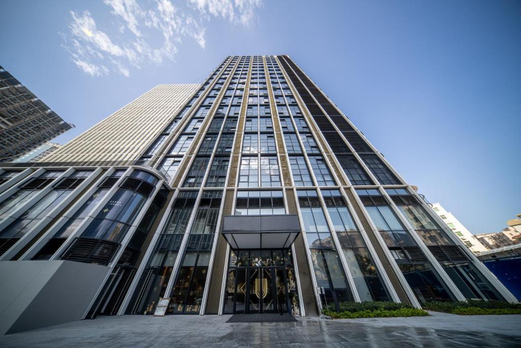un edificio alto de cristal con una puerta giratoria en BORUISI Executive Apartment, en Shenzhen