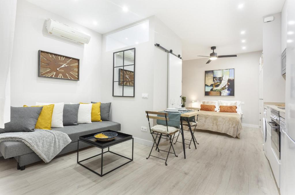 uma sala de estar com um sofá e uma mesa em Apartamento Bernabeu Comfort en Madrid em Madri