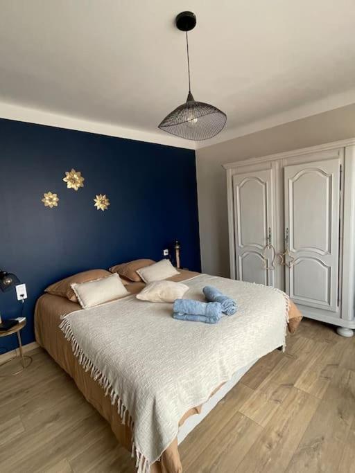 une chambre avec un grand lit avec des étoiles dorées sur le mur dans l'établissement Maison proche des plages tout confort avec Clim, à Mèze