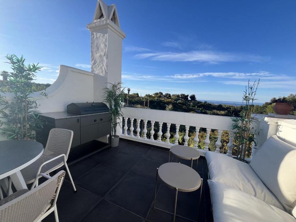 een balkon met tafels en stoelen en uitzicht op de oceaan bij Las Palmas 8b Oasis Properties in Nerja