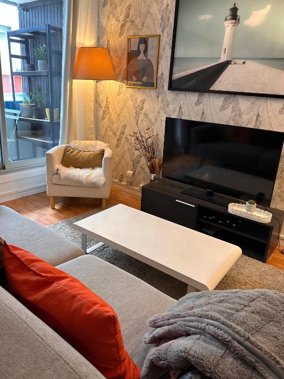 un salon avec un canapé, une table et une télévision dans l'établissement Independent studio-Center of Paris 13th arrondissement, à Paris