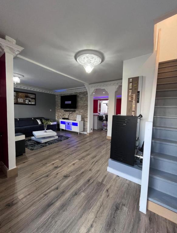 un grand salon avec un canapé et un escalier dans l'établissement Maison de Caractère à Ballainvilliers, à Ballainvilliers