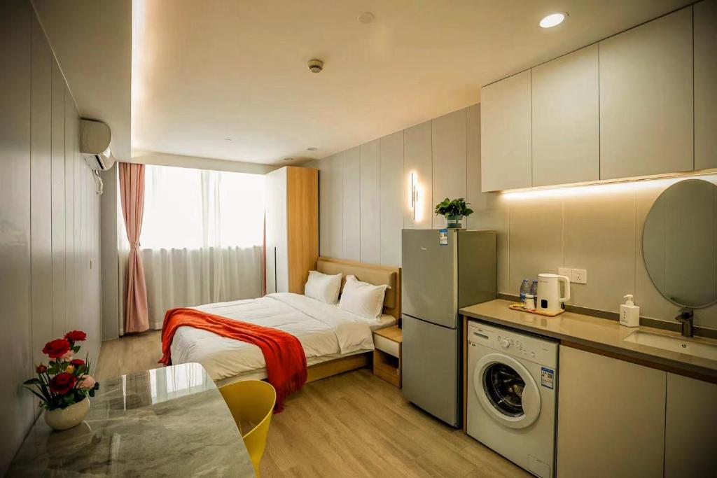 mały pokój z łóżkiem i pralką w obiekcie KeTangJian Aparthotel w Szanghaju