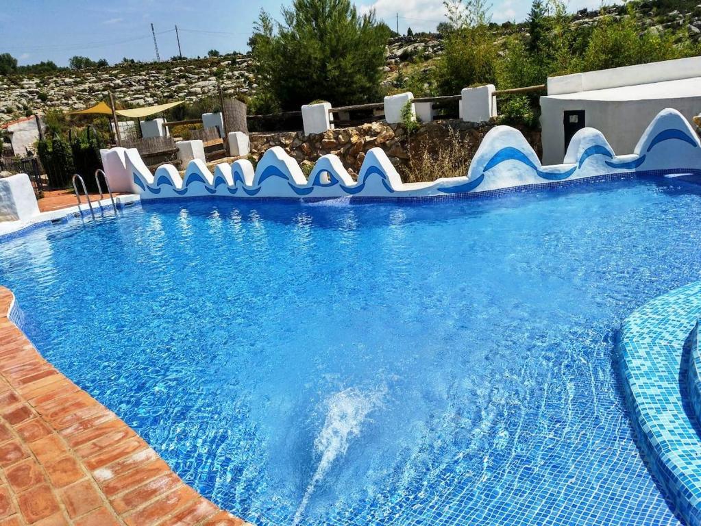 uma grande piscina azul com um escorrega aquático em El Cup em La Torre d'En Besora