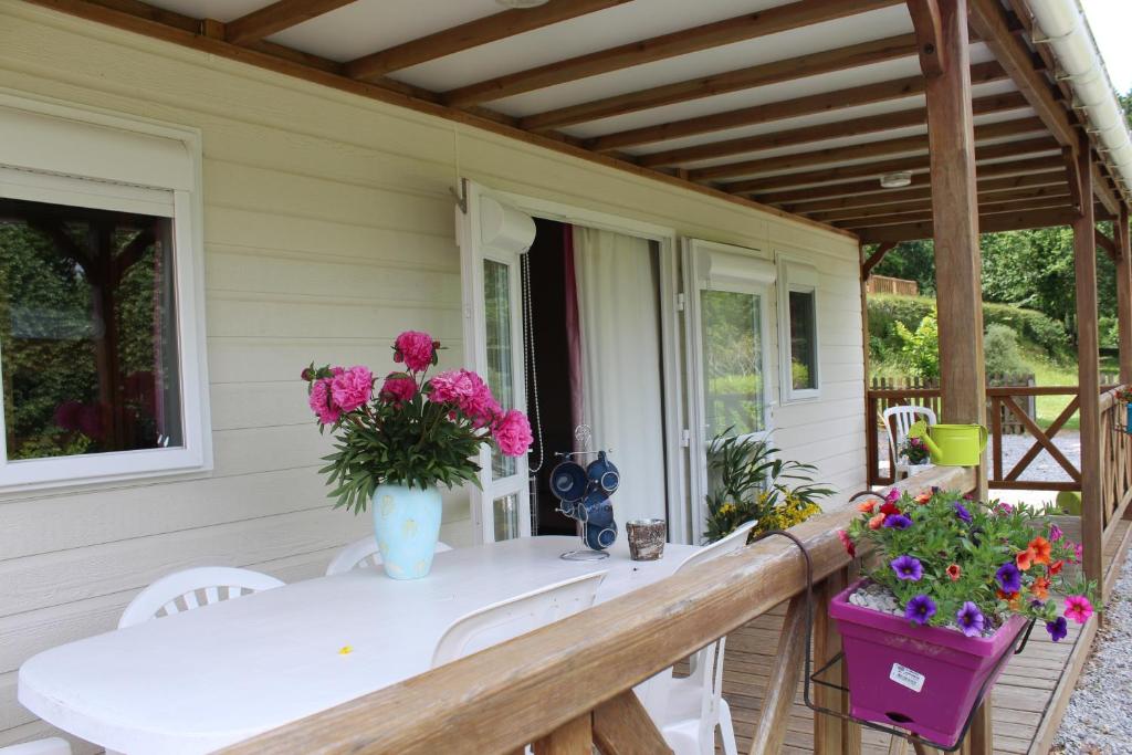 eine Veranda mit einem weißen Tisch und Blumen darauf in der Unterkunft Camping de Trezulien in Douarnenez