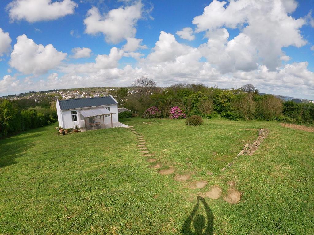une maison dans un champ avec une piste dans l'herbe dans l'établissement maisonnette pêcheur Bertheaume, à Plougonvelin