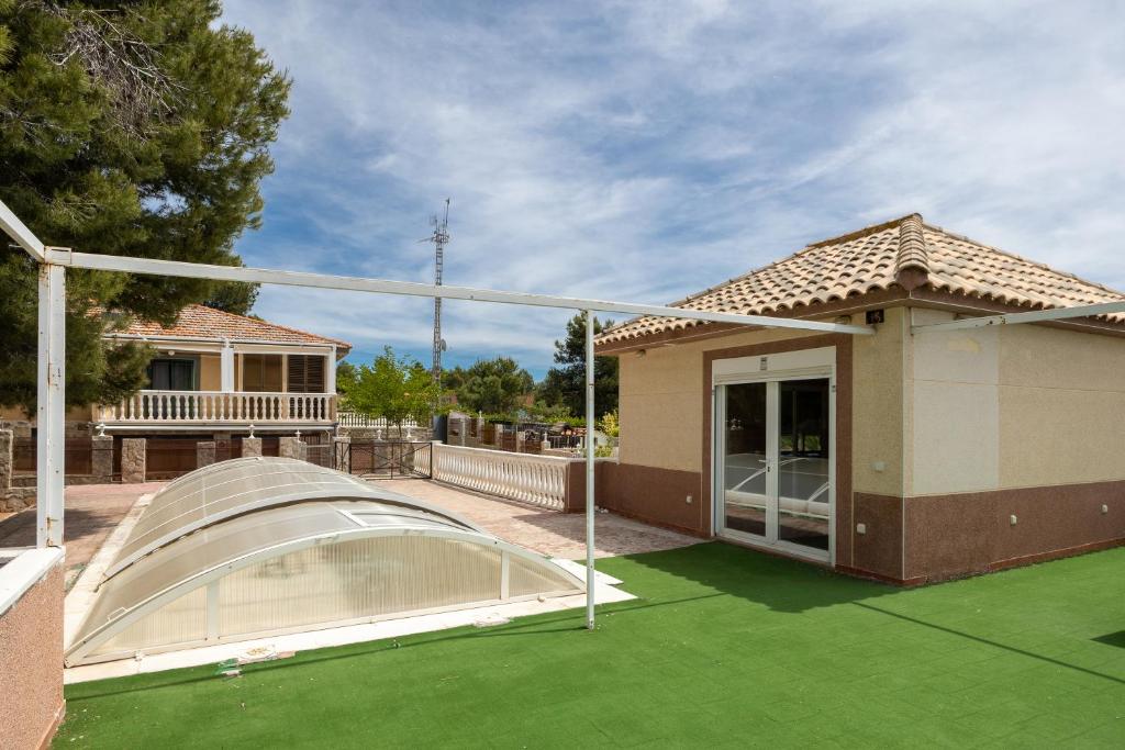a house with a cover on a green lawn at Los Naranjo in Villamanrique de Tajo