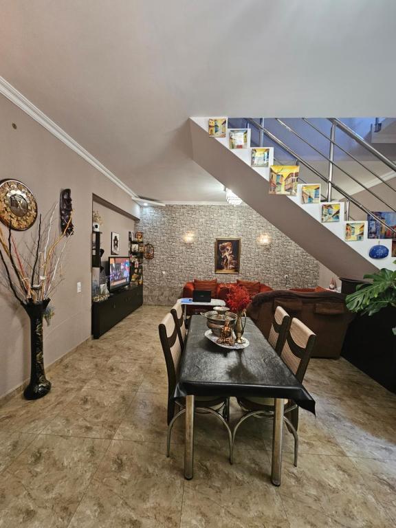 Guesthouse different في تبليسي: غرفة معيشة مع طاولة ودرج