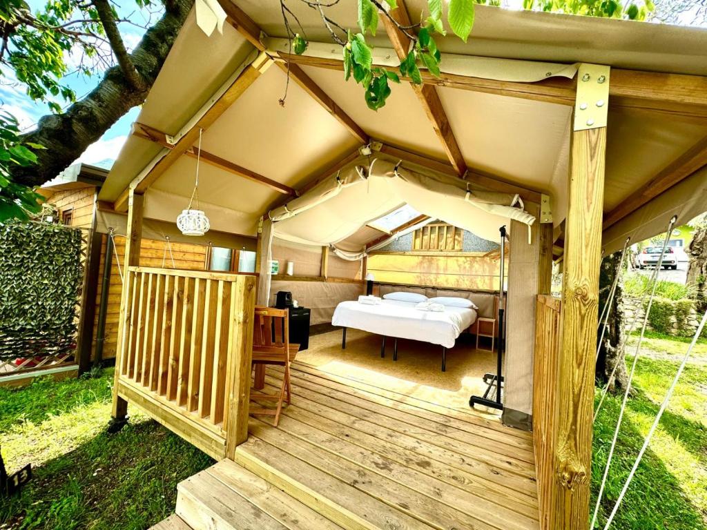 a tent with a bed on a wooden deck at Camping Monja in Brenzone sul Garda