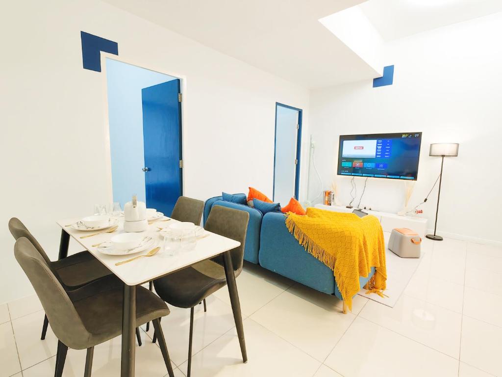 a living room with a table and a blue couch at The Popoli Icon City Petaling Jaya in Kampong Baharu Sungai Way