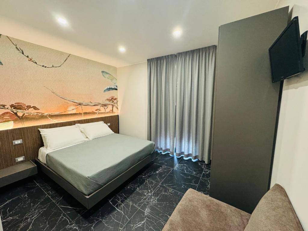 um quarto com uma cama e um quadro na parede em Residenza Arena em Tropea