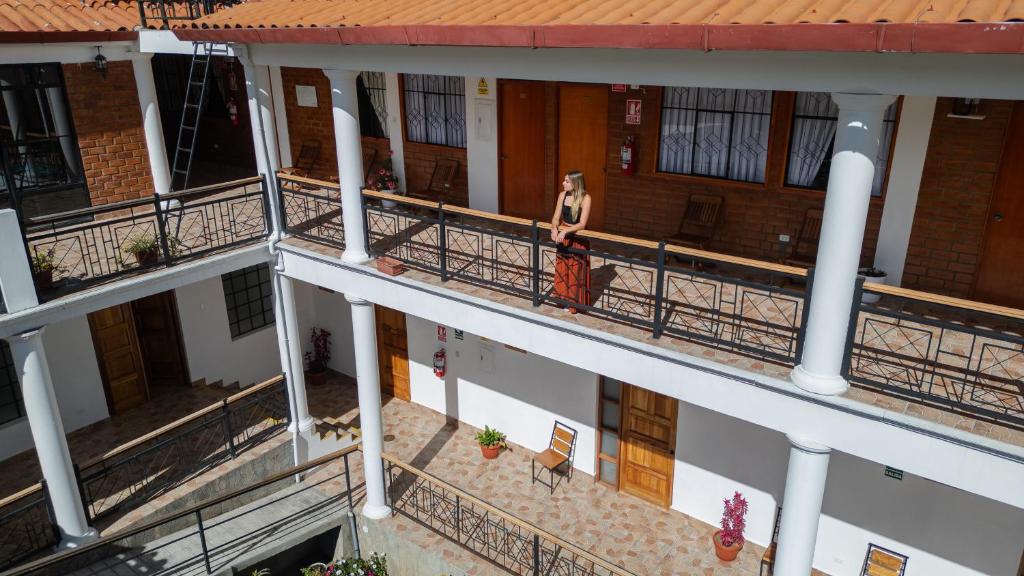 a woman walking on the balcony of a building at Tupac Huaraz in Huaraz