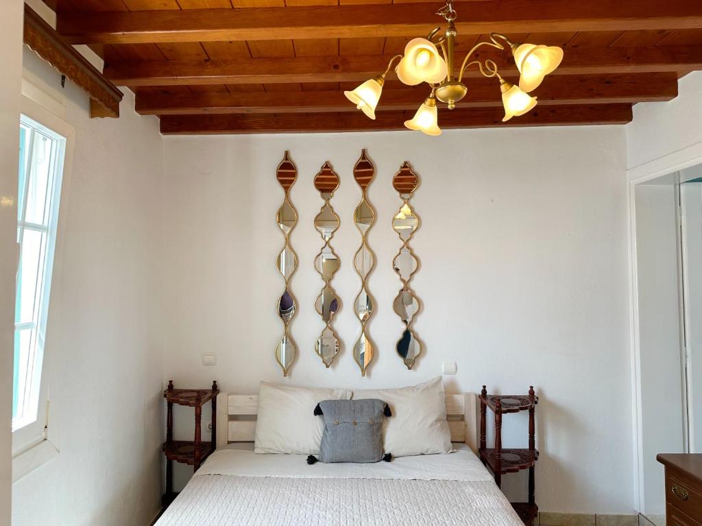 1 dormitorio con cama y lámpara de araña en Classy Classic en Mykonos ciudad