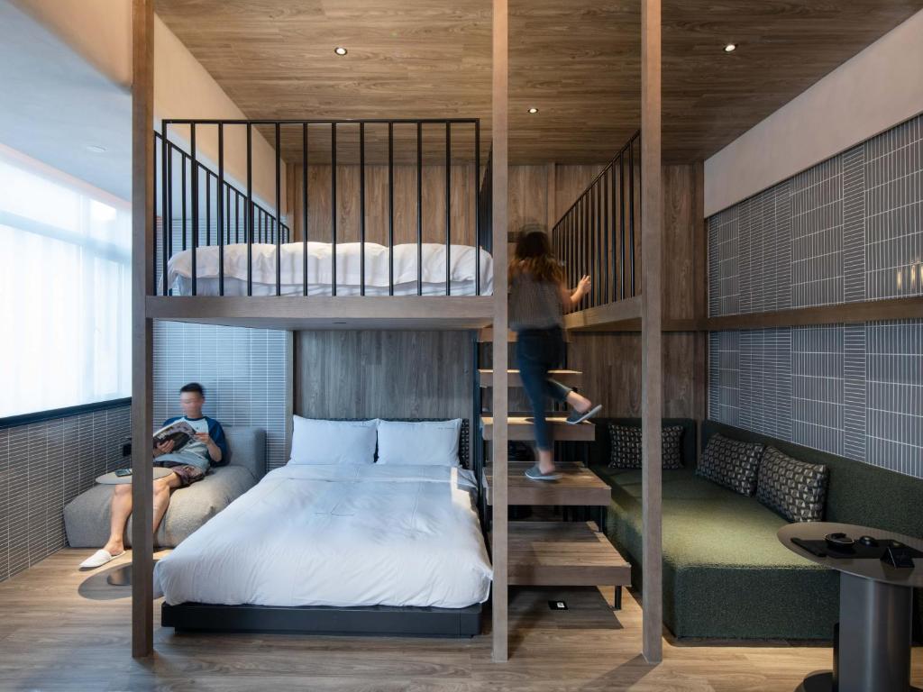 ein Schlafzimmer mit einem Etagenbett und ein paar Personen in der Unterkunft NOA Hotel & SPA Shenzhen in Shenzhen