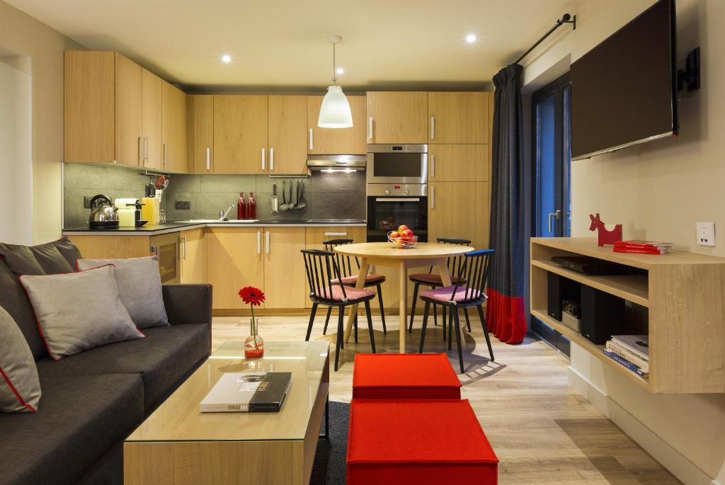 a living room and kitchen with a couch and a table at Appartements de l'Héliopic in Chamonix-Mont-Blanc