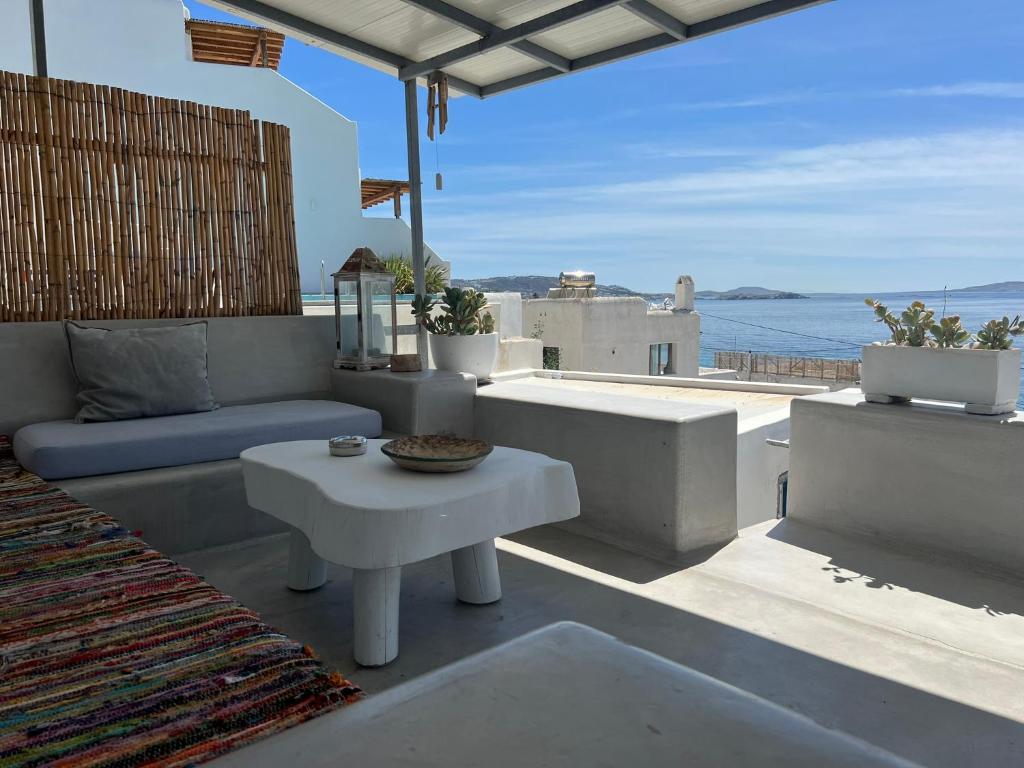 a patio with a table and a view of the ocean at Mykonos Tourlos Nests - Sea View Escape in Tourlos