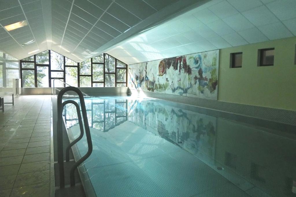 a swimming pool in a building with a pool at PETER Seeblick Appartement Haus Hänsel Gretel am Ossiacher See, Hallenbad, Skiarena Gerlitzen in Unterberg