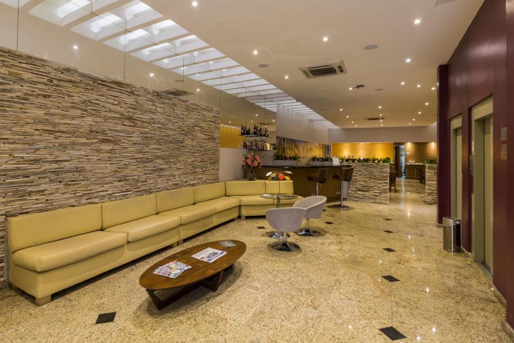 a living room with a couch and a brick wall at Pompeu Rio Hotel in Rio de Janeiro