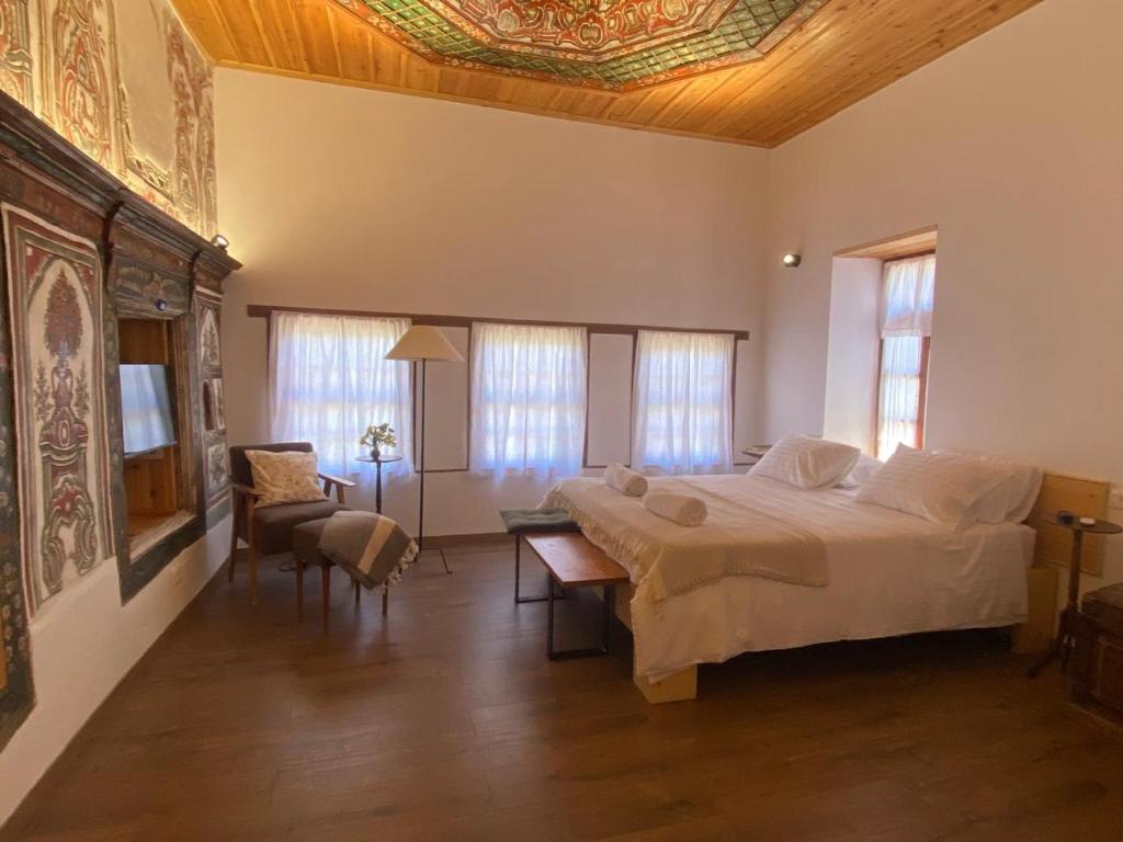een slaapkamer met een groot bed en een tafel bij Belaj's House in Gjirokastër