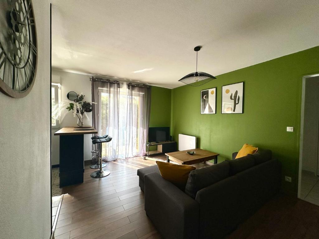 een woonkamer met groene muren en een bank bij L'évasion verte in Langres