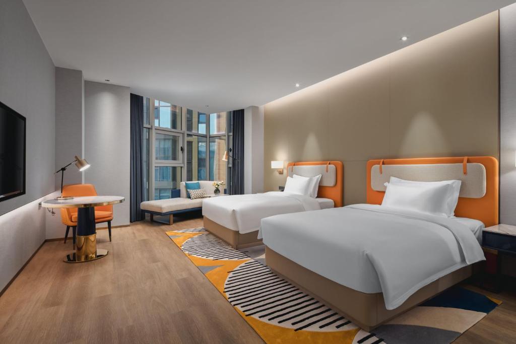 Habitación de hotel con 2 camas y sofá en voco Xi'an Qindu Legend, an IHG Hotel en Xi'an