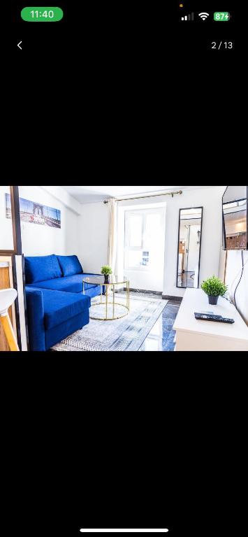 un salon avec un canapé bleu et une table dans l'établissement Studio charmant, à Nice