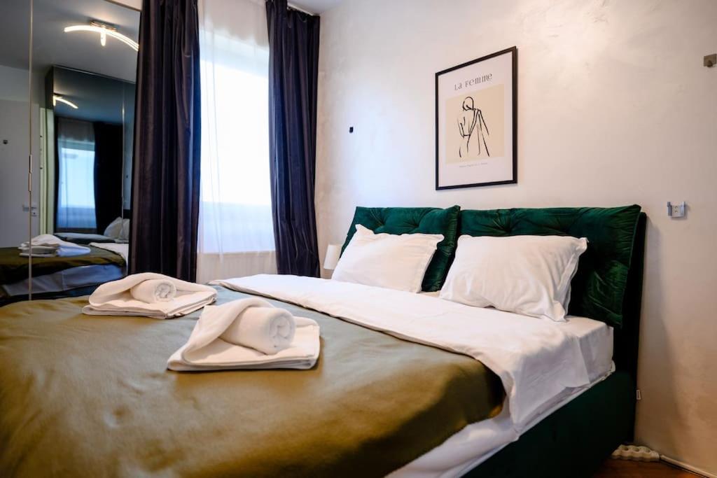 a bedroom with a bed with two hats and towels on it at Northern Horizon in Voluntari