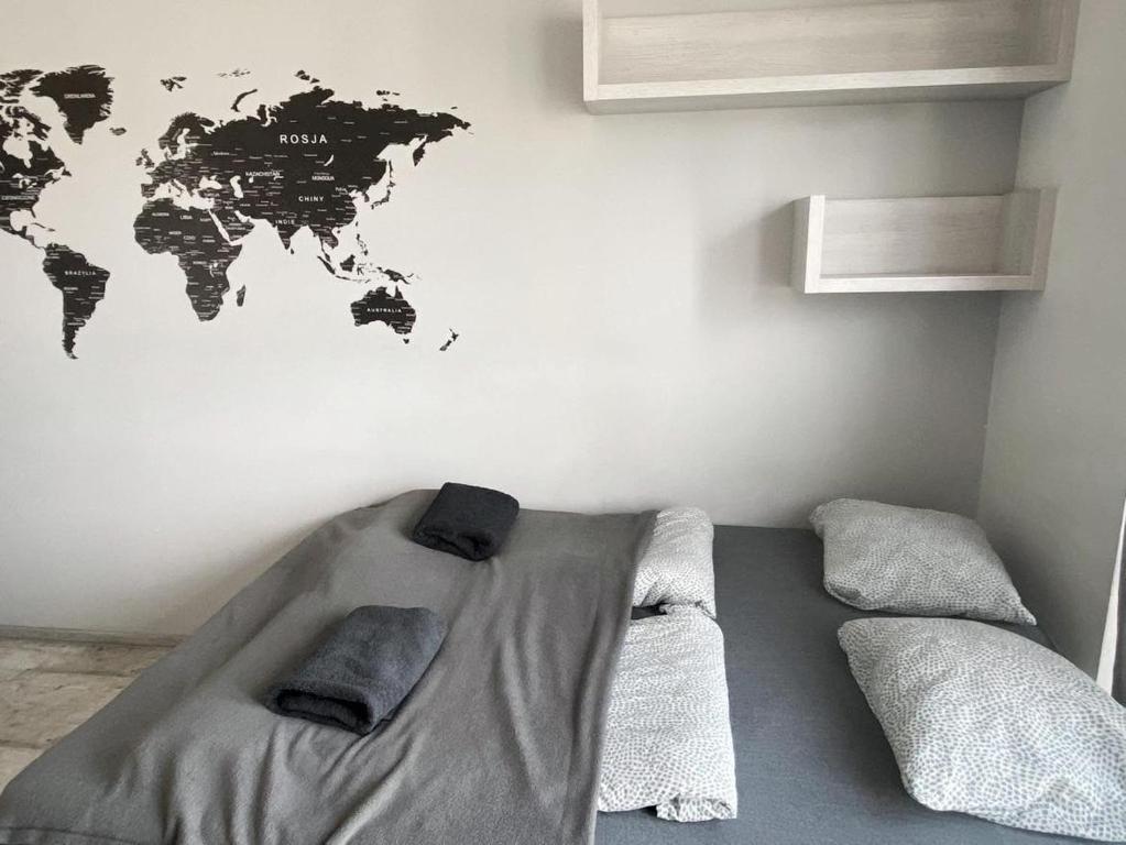 a bedroom with a bed with a world map on the wall at TOM ROOM - Cracow City Centre in Krakow