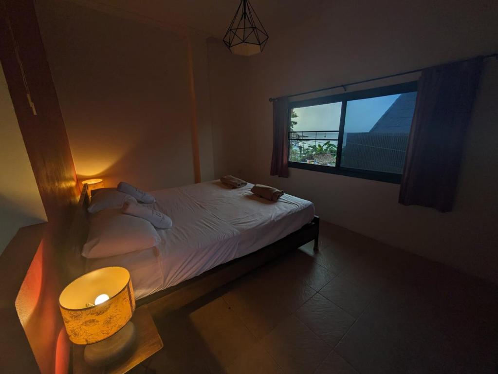 Habitación pequeña con cama y ventana en Goodtime Utopia Guesthouse en Ko Tao