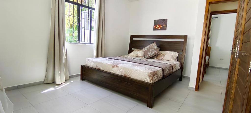 1 dormitorio con 1 cama en una habitación con ventana en Garuda Villa en Trou aux Biches
