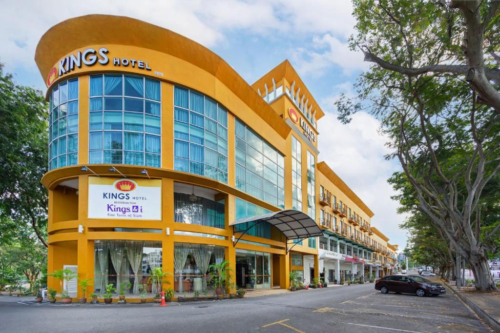 een geel gebouw met een auto ervoor geparkeerd bij Kings Hotel Melaka in Melaka