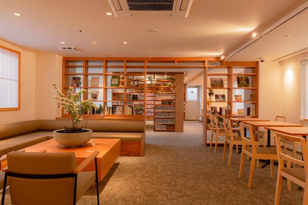 un restaurante con mesas y sillas y una biblioteca en Matsumoto Tourist Hotel en Matsumoto