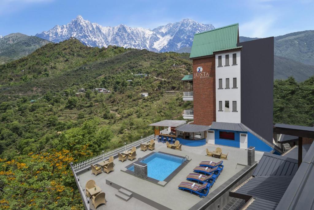 an aerial view of a hotel with a pool and mountains at juSTa Birding Resort & Spa - Best Dhauladhar View Resort in Dharamshala