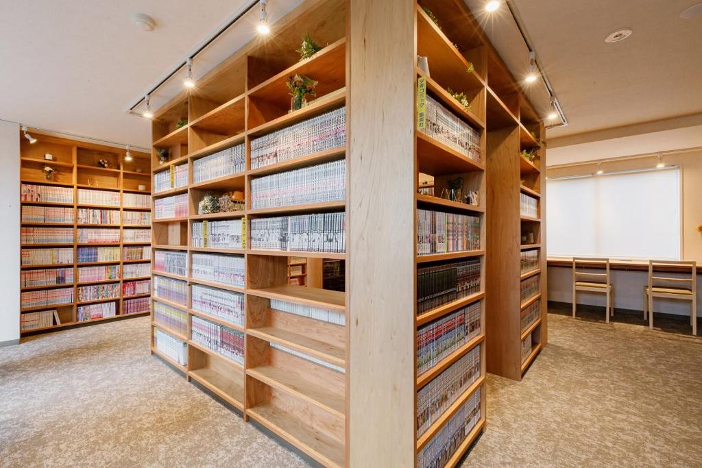a library with wooden shelves filled with books at Matsumoto Tourist Hotel in Matsumoto