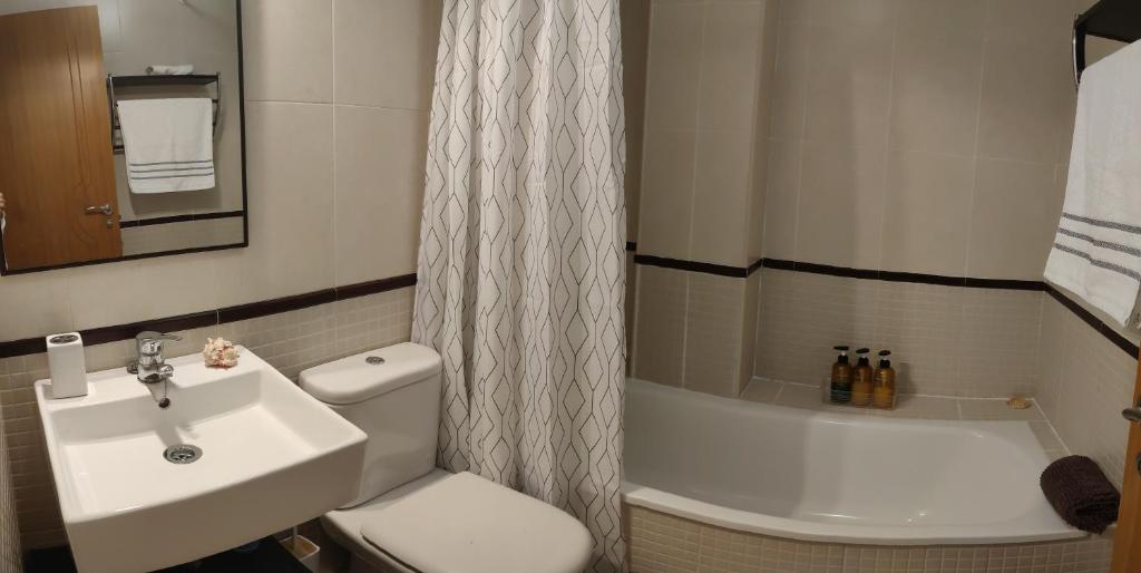 uma casa de banho com um lavatório, um WC e uma banheira em ÁTICO Vilagarcía em Vilagarcía de Arousa
