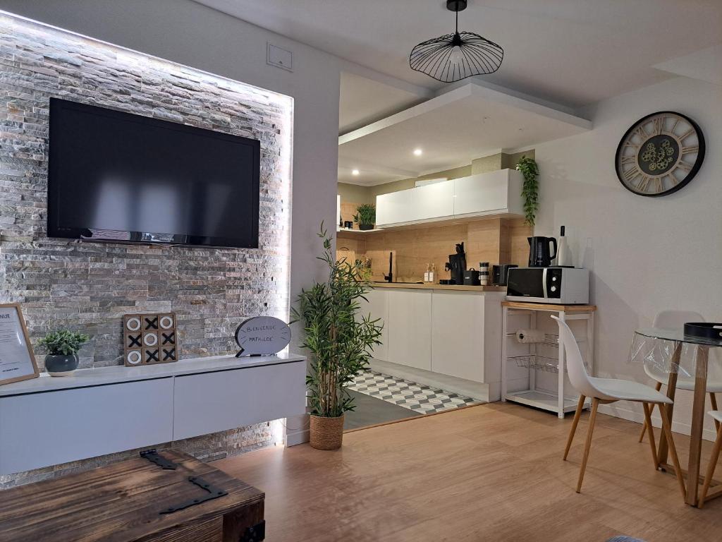 kuchnia i salon z telewizorem na murze w obiekcie Bel Appartement, Sélestat w mieście Sélestat