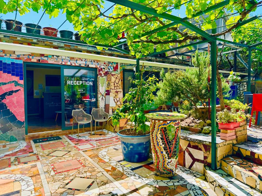 eine Terrasse mit Topfpflanzen und einem Tisch in der Unterkunft HOSTEL ART & JOY in Pula