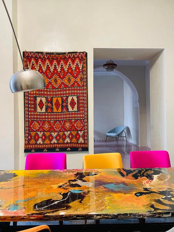 une salle à manger avec une table et des chaises colorées dans l'établissement Riyad Lion Rouge, à Marrakech