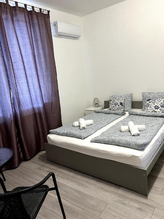 a bedroom with two beds and a purple curtain at Aniiza Apartman 2 in Örvényes