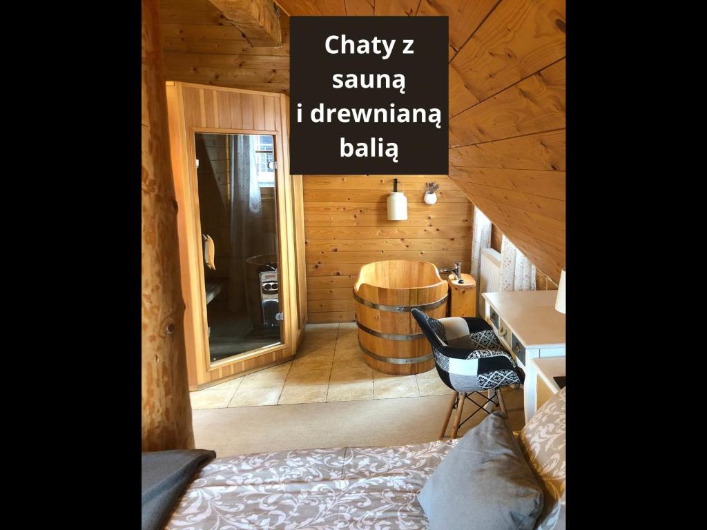 カルパチにあるChaty Świerkowe Wzgórzeのベッド、デスク、樽が備わる客室です。
