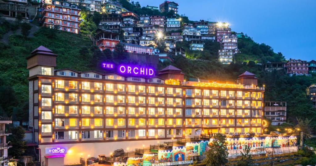 um edifício com um sinal em cima em The Orchid Hotel Shimla em Shimla