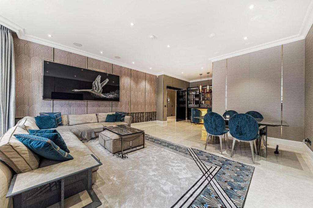 ein Wohnzimmer mit einem Sofa und einem Tisch in der Unterkunft Piccadilly Green Park Apartment in London