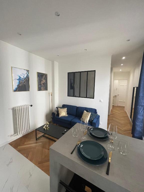 un salon avec une table et un canapé bleu dans l'établissement Appart Cosy, Proche Gare, à Nice